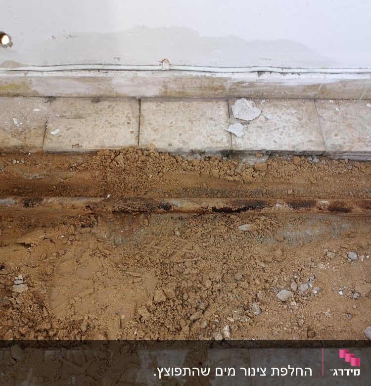 תעלה פתוחה ברצפה עם צינור חשוף ועפר